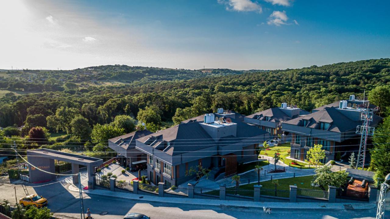 Menalo Hotel Premium Istanbul Airport Exterior photo The photo shows a scenic landscape featuring modern residential buildings situated amidst a lush green environment. The houses have dark roofs and are designed with multiple levels. Surrounding the homes is well-maintained landscaping, including tree